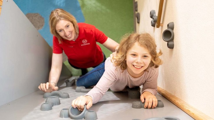 Kind und Betreuerin auf der Kletterwand des Familotel Sonnenpark