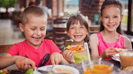 Lachende Kinder essen in einem Restaurant