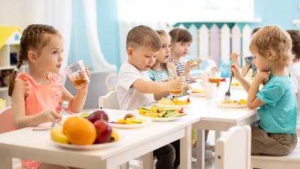 Gruppe Kinder isst gesunde Mahlzeit in Kita