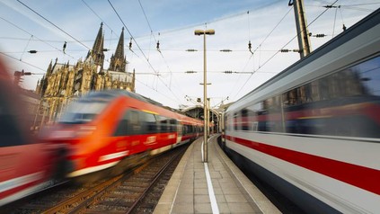 Vorbeirasende Züge an einem Bahnhof