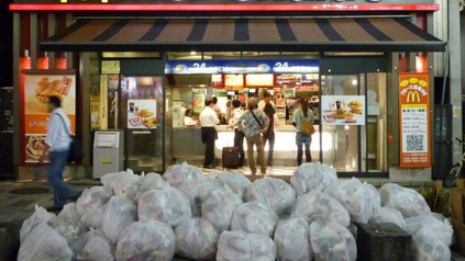 Vor einer McDonald's Filiale stapeln sich weiße Müllsäcke