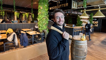 Romain Félix, Gründer aus Belgien, steht mit einer Axt im Woodcutter.
