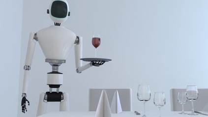 Ein Roboter steht mit einem Tablett und einem Glas Wein vor einem gedeckten Tisch