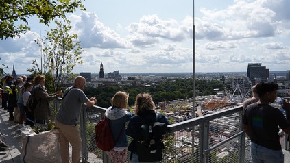 Besucher der Dachterrasse auf dem begrünten Hochbunker genießen den Ausblick über Hamburg und das Heiligengeistfeld