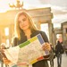 Frau steht mit Stadtplan vor dem Brandenburger Tor