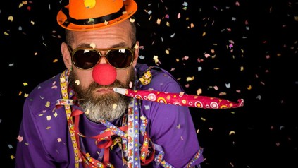 Mann mit Clownsnase und Konfetti in der Luft