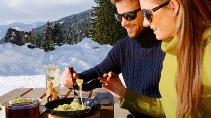 Mann und Frau essen draußen bei Schnee