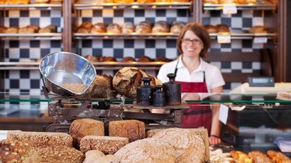 Bäckerin in Bäckerei vor Brot