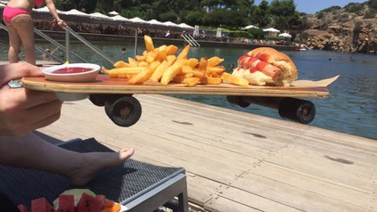 Pommes mit Hot Dog und Ketchup auf Skateboard serviert