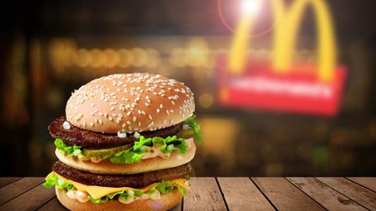 Ein Big Mac vor einem McDonaldslogo