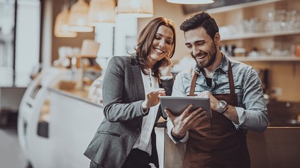 Zwei Gastronomen schauen im Betrieb auf Tablet